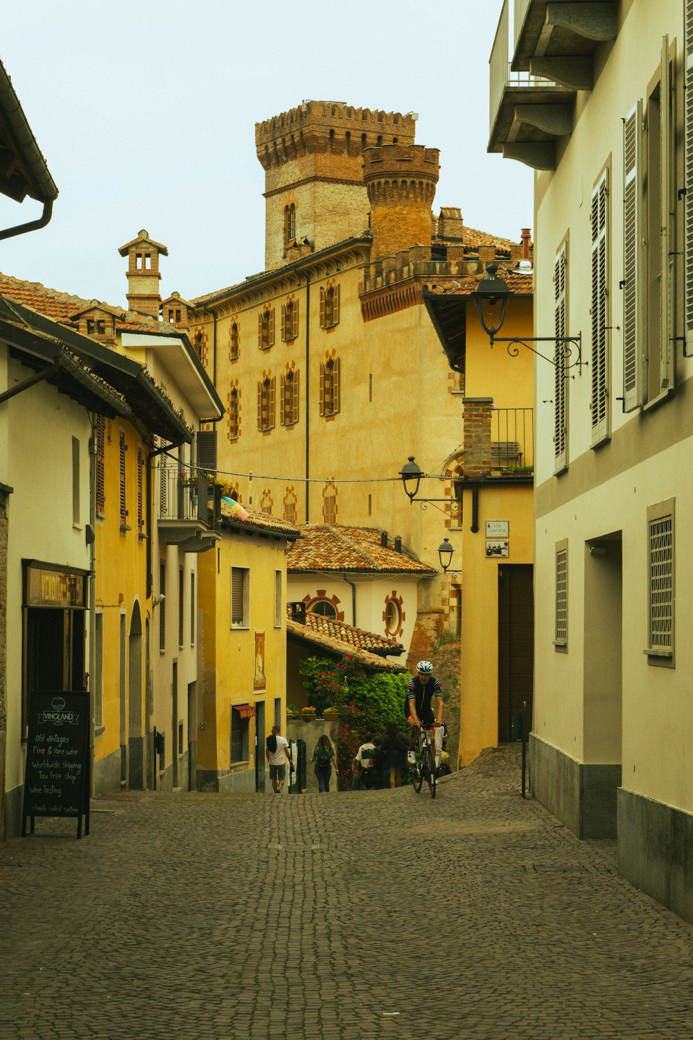 Langhe e Alba in autunno: guida tra tartufo bianco, Barolo e borghi delle colline UNESCO 2 Via acciottolata del borgo di Barolo con case color ocra che sale verso le torri merlate del Castello Falletti, sede del museo del vino WiMu