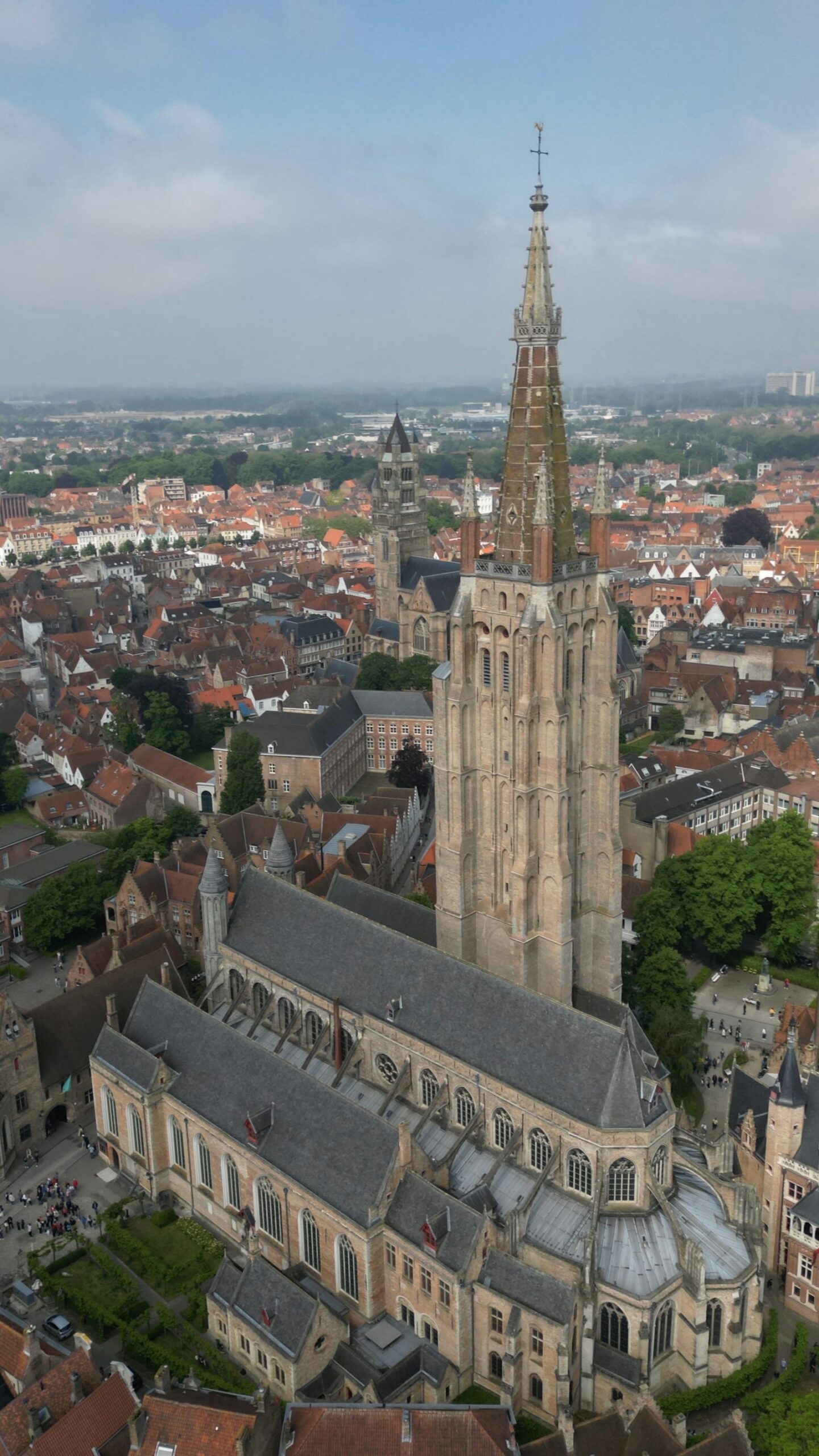 Bruges, Belgio: guida city break tra Markt, canali e Begijnhof 3 Vista aerea della Chiesa di Nostra Signora di Bruges con il campanile in mattoni e i tetti rossi del centro storico