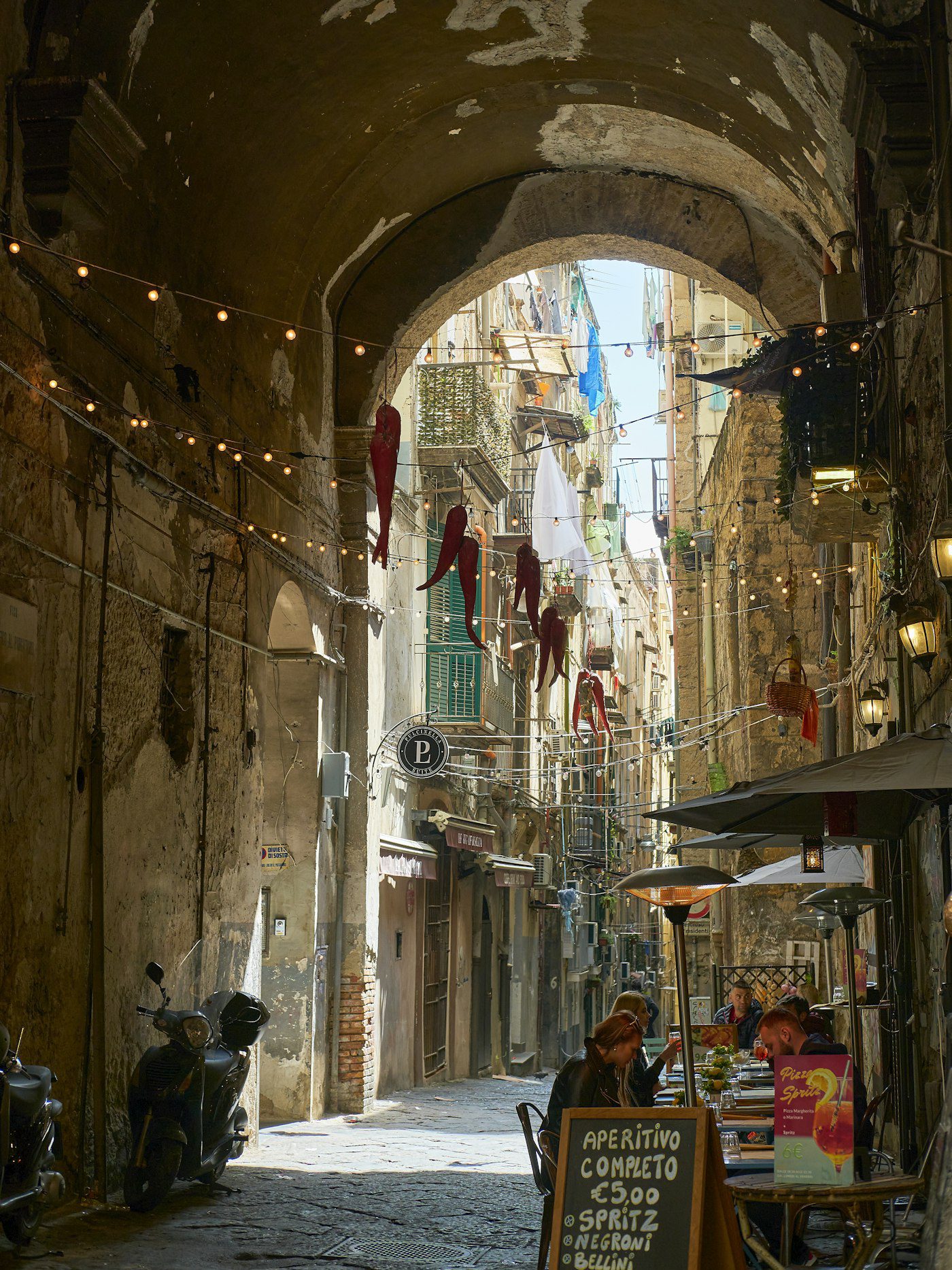 Napoli e la Coppa America 2027: guida viaggio tra Golfo, Bagnoli e city break 5 Vicolo del centro storico di Napoli con cornicelli, panni stesi e vita di quartiere.