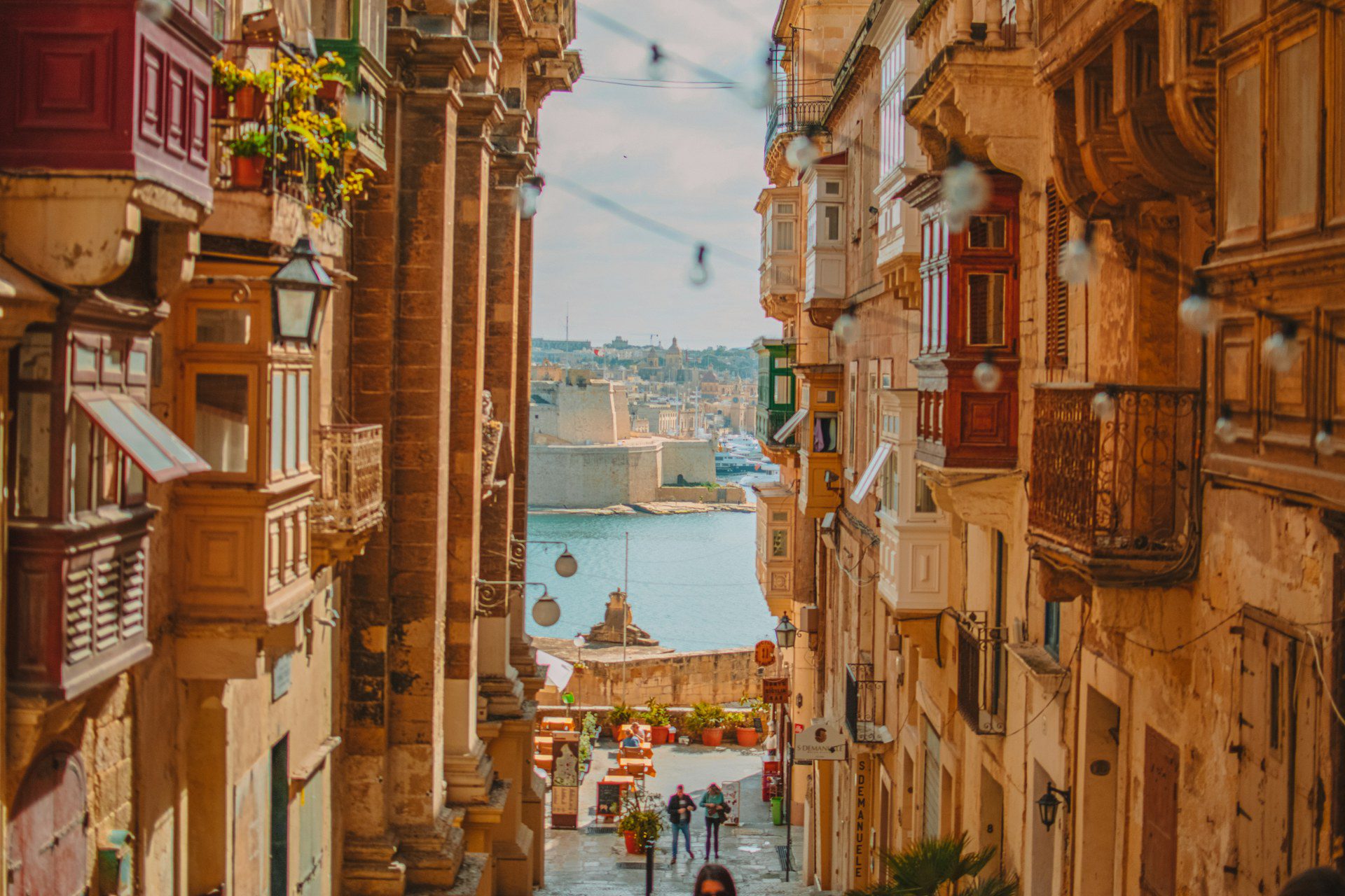 La Valletta, Malta: guida city break tra Concattedrale, Barrakka e Grand Harbour 3 Strada a gradini della Valletta con i tradizionali balconi in legno colorati e il Grand Harbour con le fortificazioni delle Tre Città sullo sfondo
