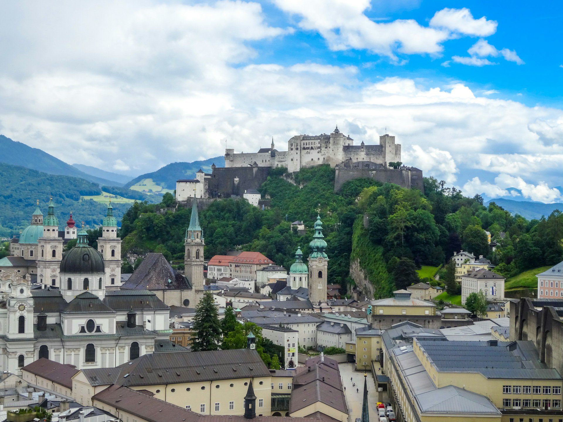 Salisburgo, Austria: guida city break tra Mozart, Fortezza e Città Vecchia 2 Panorama di Salisburgo dal Mönchsberg con le cupole verdi delle chiese barocche, i tetti della città vecchia e la Fortezza di Hohensalzburg davanti alle montagne