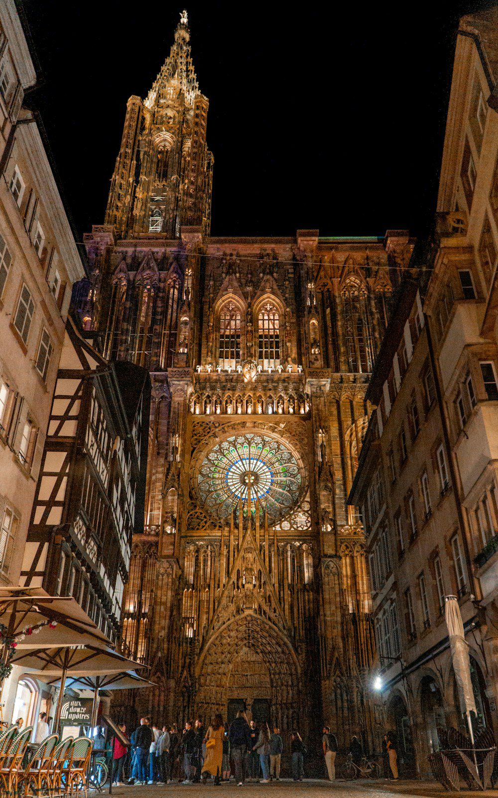 Strasburgo, Francia: guida city break tra Cattedrale, Petite France e mercatini di Natale 1 La facciata gotica della Cattedrale di Notre-Dame di Strasburgo illuminata di notte, con il grande rosone, la guglia e le case di rue Mercière ai lati